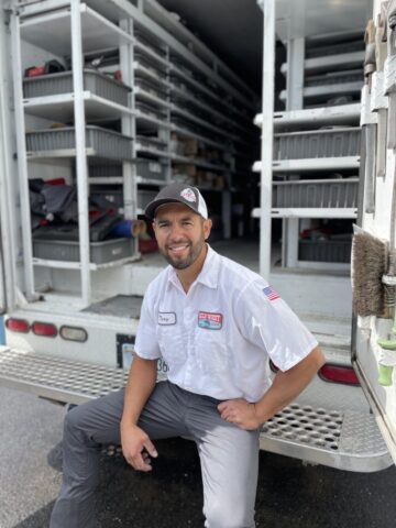 Wild West Plumbing technician in uniform sitting on company work truck step before a service call in Kalispell MT.